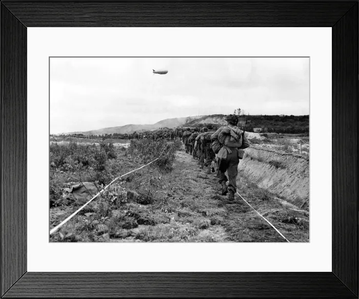 Framed Print : American infantrymen move along a taped path through a German minefield after their beach Framed Print : American infantrymen move along a taped path through a German minefield after their beach