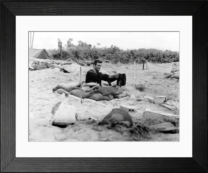 Framed Print : A soldier hangs a pair of socks on a washing line outside his fox hole on a French beach Framed Print : A soldier hangs a pair of socks on a washing line outside his fox hole on a French beach