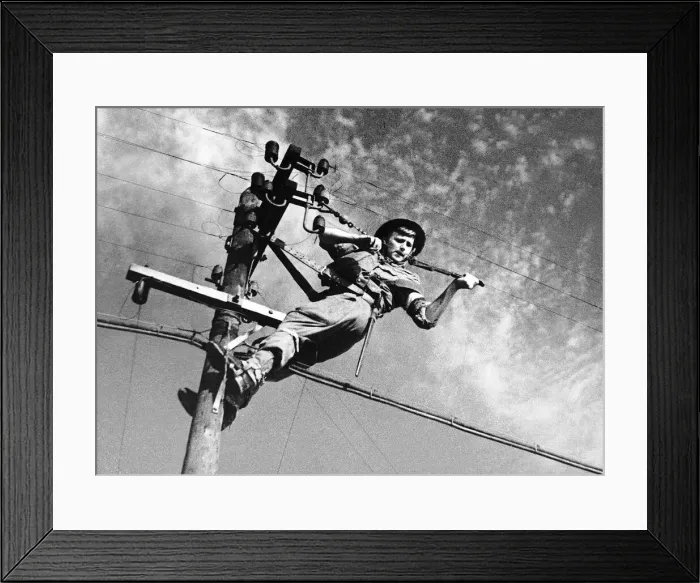 Framed Print : A British Army signalman at the top of a telegraph pole maintaining communication during