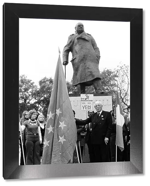 Harold MacMillan March 1975 holding the European flag under the statue of Sir Winston