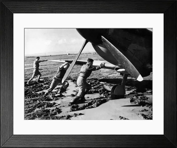 Framed Print : An RAF ground crew pushes a Supermarine Spitfire out of the mud on a boggy Framed Print : An RAF ground crew pushes a Supermarine Spitfire out of the mud on a boggy