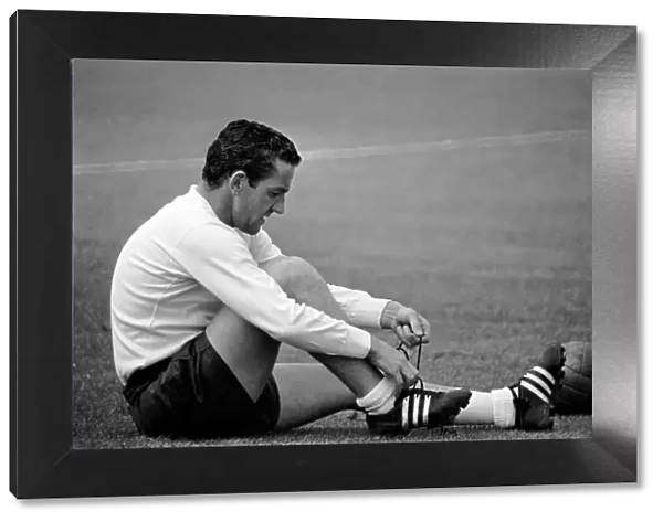 Tottenham Hotspur player Dave Mackay ties up his boot laces during a pre-season training