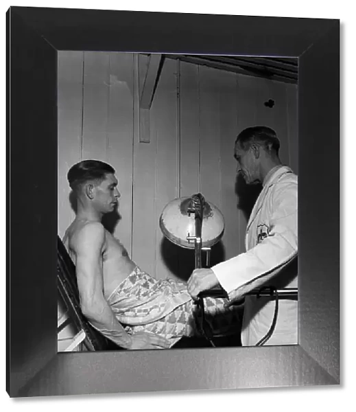 Fulham F. C. Trainer F Penn treats Jimmy Taylor for injury. March 1949 O17597