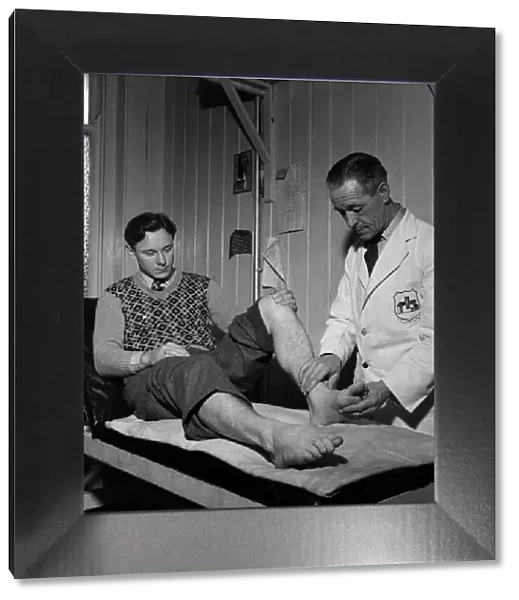Fulham F. C. Trainer F Penn treats injured leg. March 1949 O17597-001