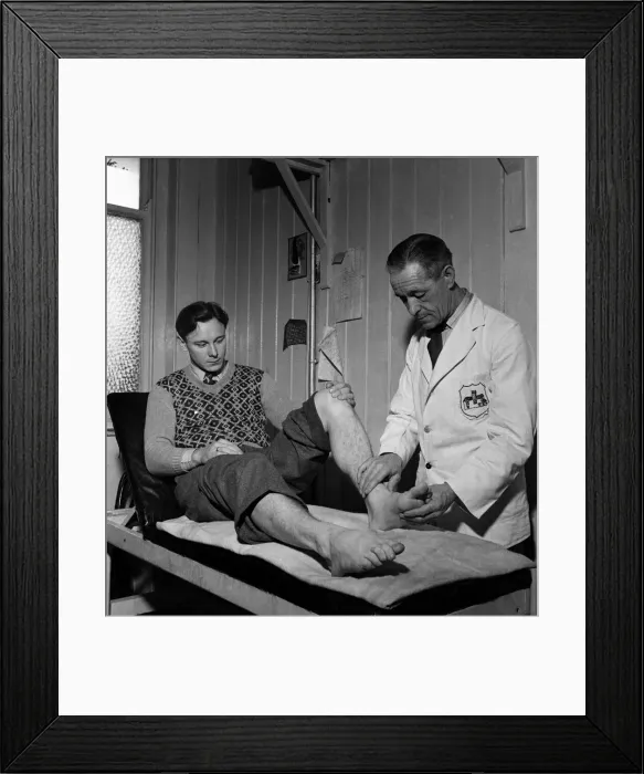 Framed Print : Fulham F. C. Trainer F Penn treats injured leg. March 1949 O17597-001 Framed Print : Fulham F. C. Trainer F Penn treats injured leg. March 1949 O17597-001