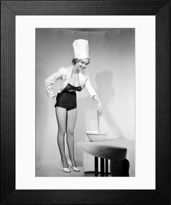 Framed Print : Woman modelling black lingerie and a chefs hat in a cooking photo shoot. Circa 1964 Framed Print : Woman modelling black lingerie and a chefs hat in a cooking photo shoot. Circa 1964