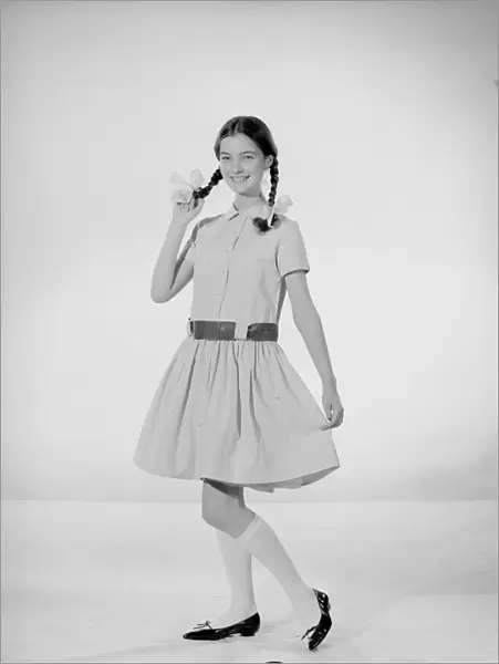 Model Jennifer Goddard. Brown-haired girl in checkered dress with pig tails