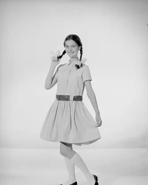 Model Jennifer Goddard. Brown-haired girl in checkered dress with pig tails
