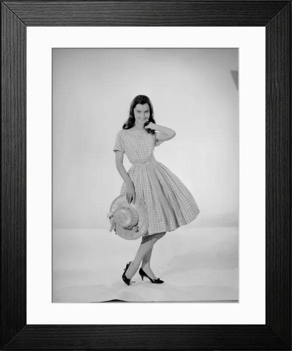 Framed Print : Model Jennifer Goddard. Brown-haired girl in checkered dress with hat