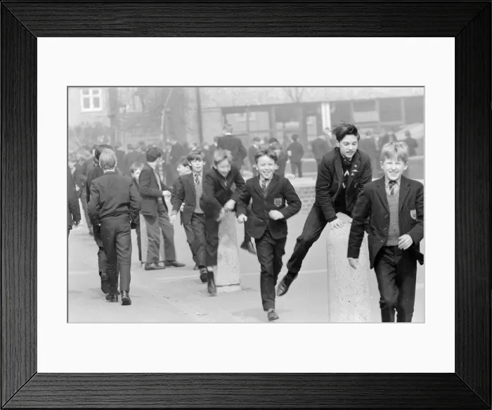 Framed Print : Children of a London Comprehensive school leap frogging over one of the concrete pillars