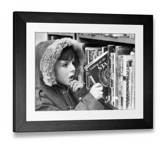 Framed Print : Five year old Christopher Blanks makes his reading selection at Low Fell library Framed Print : Five year old Christopher Blanks makes his reading selection at Low Fell library