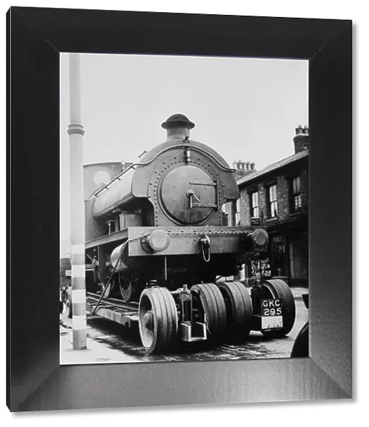 A locomotive train is drawn through the streets of Stretford on the way to the repair