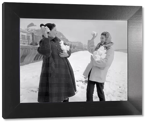 Two women having a snowball fight on Hastings beach. 8th March 1955