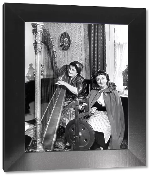 One lady playing the harp while her friend is spinning in April 1960