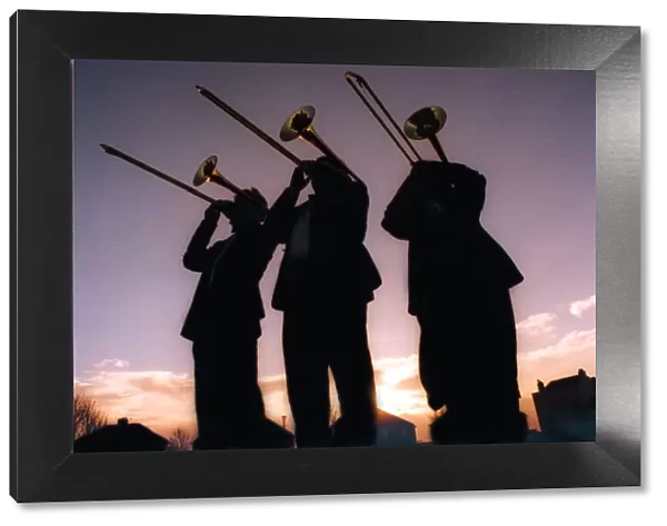 Silhouettes of men playing trombones on December 18, 1997