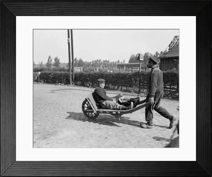 Framed Print : A wounded Belgian soldier is wheeled away from the battlefield close to the town of Framed Print : A wounded Belgian soldier is wheeled away from the battlefield close to the town of