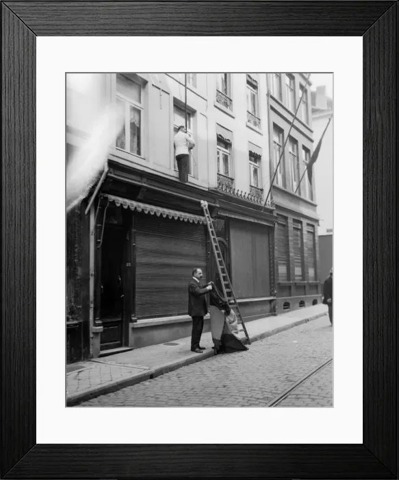 Framed Print : Shop owners taking down the Belgium flags before Louvain is occupied by the advancing