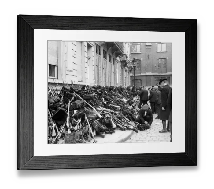 Framed Print : Members of the Civic Guard pile arms and equipment before the Germans enter the city of
