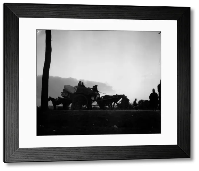 Framed Print : Dawn breaks on the Antwerp road revealing a line of refugees making for the city ahead of