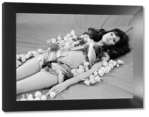Actress MAdeline Smith lying on a bed covered with garlic and lettuce