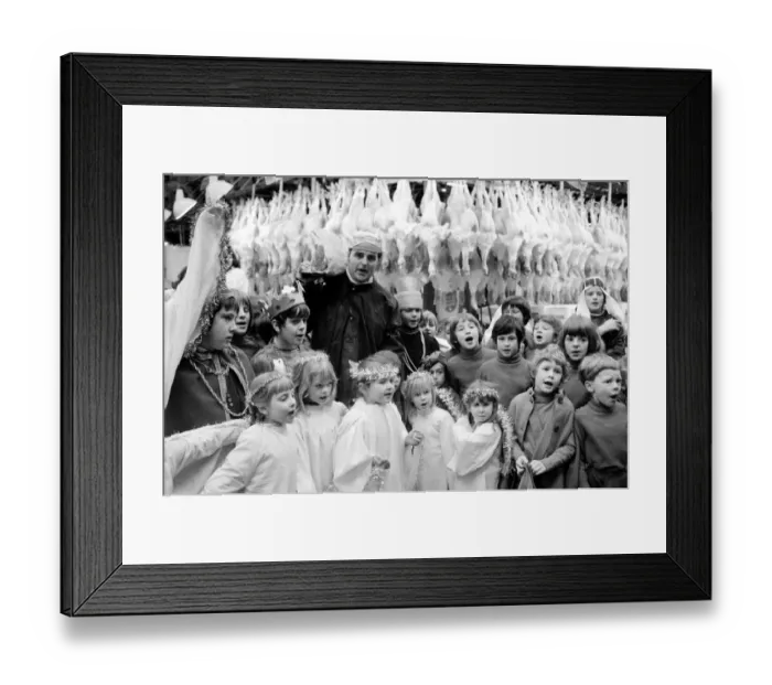 Framed Print : Terry Champion of Hornsey, London, joins the children in carol singing during his work