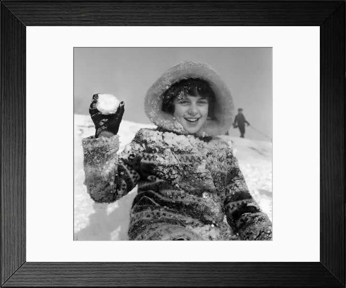 Framed Print : Children playing in the snow on Hampstead Heath, A girl holds a snowball during a Framed Print : Children playing in the snow on Hampstead Heath, A girl holds a snowball during a