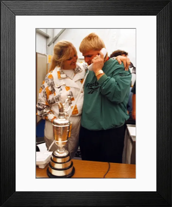 Framed Print : John Daly phones home to his parents in the USA watched by his wife Paulette after