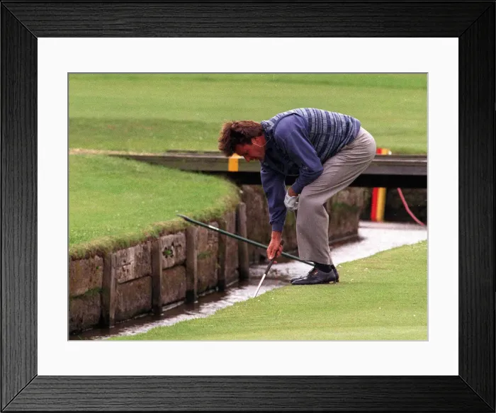 Framed Print : Nick Faldo retrieves his ball from the Swilken burn at the 1st after putting his ball in Framed Print : Nick Faldo retrieves his ball from the Swilken burn at the 1st after putting his ball in