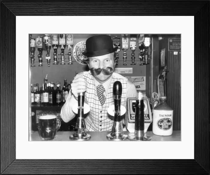 Framed Print : Barman Bobby Moore heavily disguised, poses for publicity picture at his East End pub Framed Print : Barman Bobby Moore heavily disguised, poses for publicity picture at his East End pub