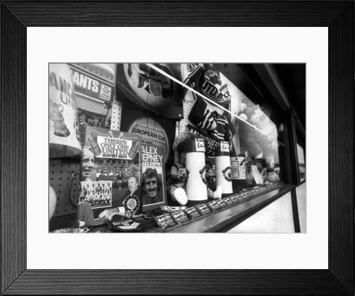 Framed Print : Manchester United merchandise including books, flags and scarves on sale at a store Framed Print : Manchester United merchandise including books, flags and scarves on sale at a store