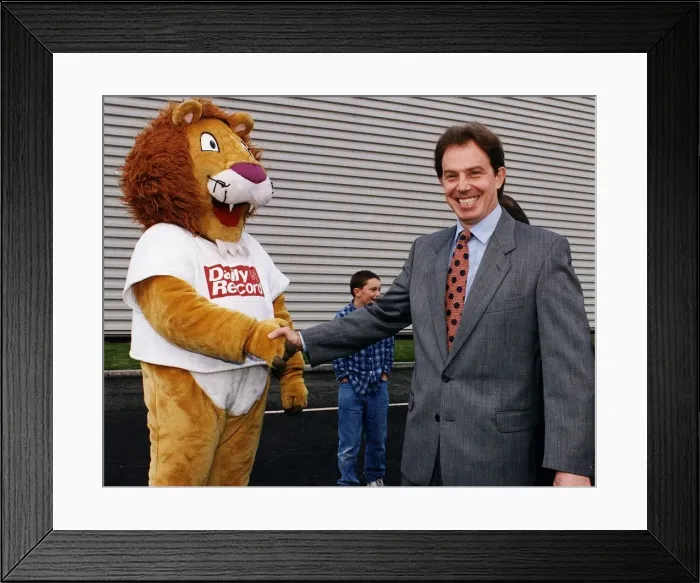 Framed Print : Tony Blair MP shaking hands with Daily Record mascot Roary the Lion at new printing plant