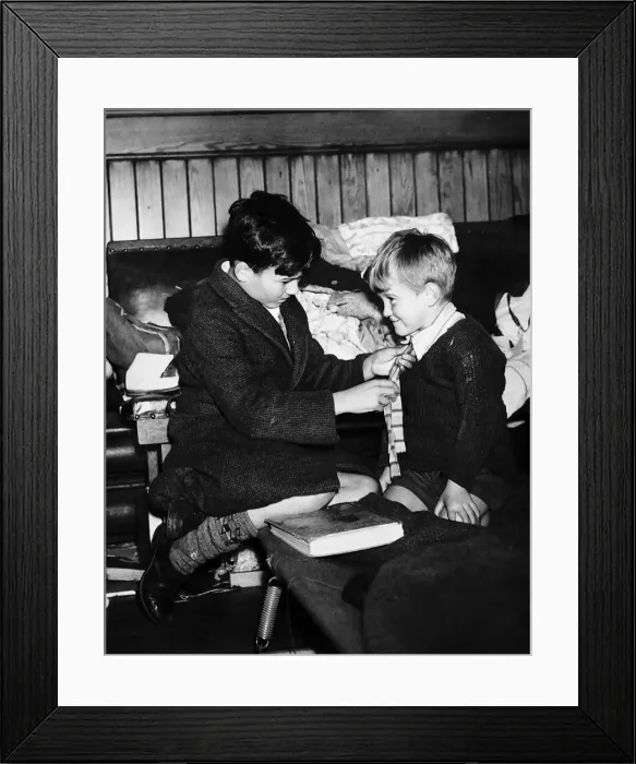 Framed Print : World War Two 1940 Evacuee boy gets a helping hand from his elder brother Framed Print : World War Two 1940 Evacuee boy gets a helping hand from his elder brother