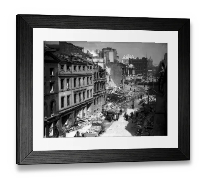 Framed Print : Civilians and rescue workers search through the the bomb damage buildings in the centre