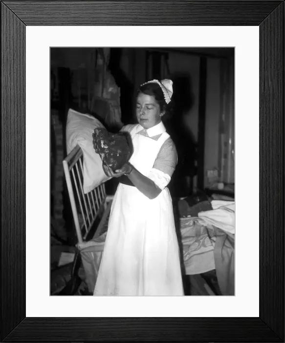 Framed Print : WW2 Air Raid Damage A nurse holds up a large stone in a hospital ward after Framed Print : WW2 Air Raid Damage A nurse holds up a large stone in a hospital ward after