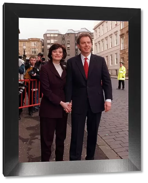 Tony Blair holding hands with wife Cherie while walking through streets of Glasgow 1997