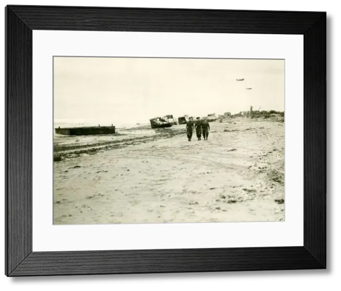 Framed Print : British troops walk along the beach in Normandy after the allied force had landed back in