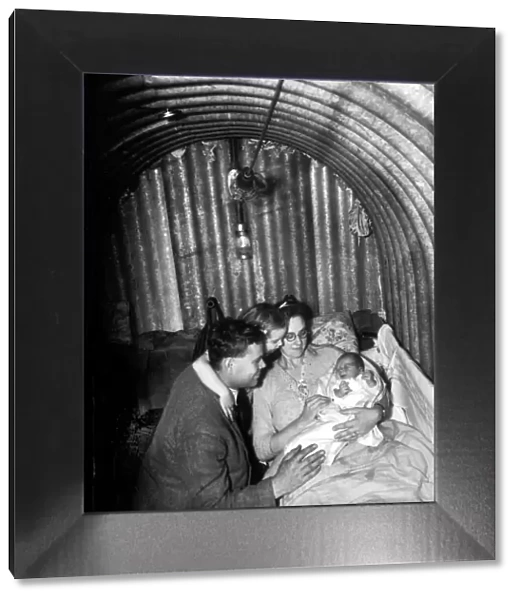WW2 A family seeks refuge inisde an Anderson Air Raid shelter during the blitz