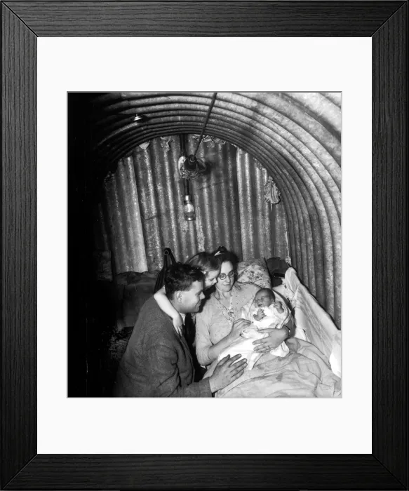 Framed Print : WW2 A family seeks refuge inisde an Anderson Air Raid shelter during the blitz