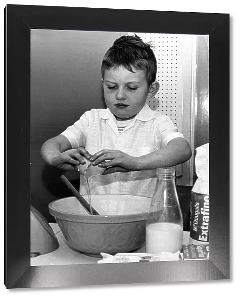 Six year old David Glass of Brighton pictured breaking eggs into a bowl to make a cake