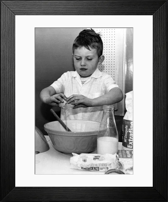Framed Print : Six year old David Glass of Brighton pictured breaking eggs into a bowl to make a cake Framed Print : Six year old David Glass of Brighton pictured breaking eggs into a bowl to make a cake