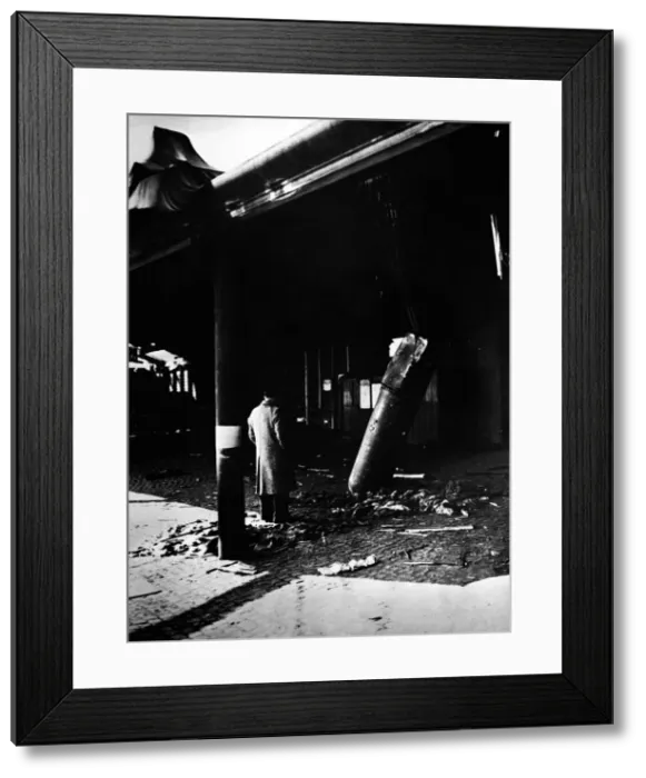 Framed Print : An onlooker examines an unexploded aerial mine comes to rest outside a railway station Framed Print : An onlooker examines an unexploded aerial mine comes to rest outside a railway station