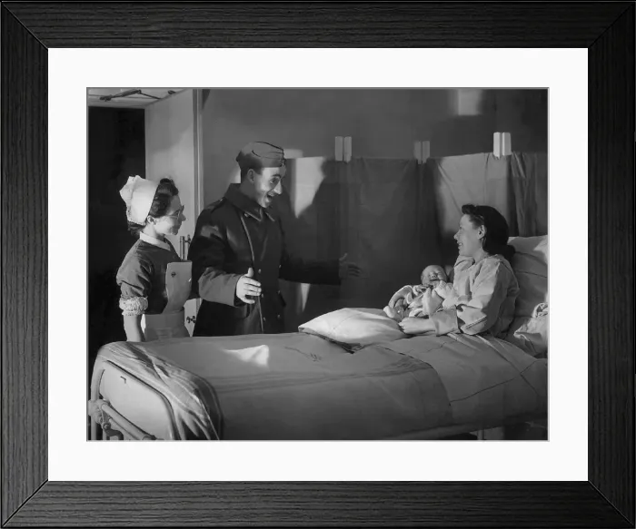 Framed Print : A British serviceman looks surprised as his wife presents him with a newborn baby Framed Print : A British serviceman looks surprised as his wife presents him with a newborn baby