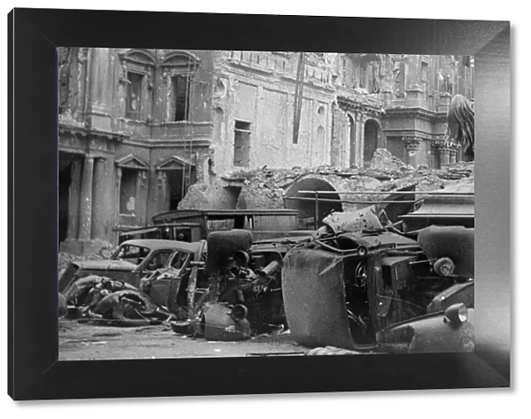 Cars lying in the road amongst the destruction caused by the Allied advance on Berlin