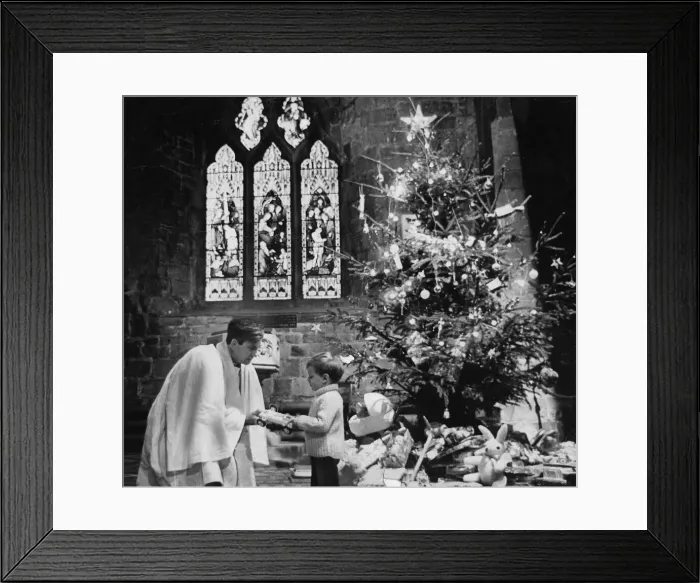 Framed Print : This little boy, like many others in his parish, is giving up an old toy to be passed Framed Print : This little boy, like many others in his parish, is giving up an old toy to be passed