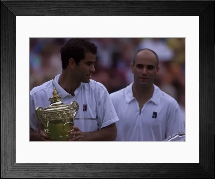 Framed Print : Pete Sampras with trophy watched by Andre Agassi after Pete had won the Mens Final
