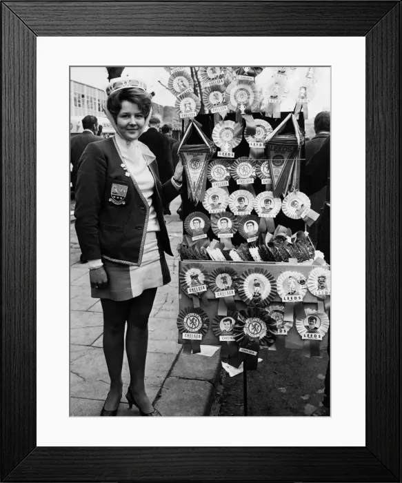 Framed Print : Leeds United supporter Mrs Barbra Pewte seen here standing beside a rosette stall outside