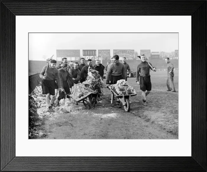 Framed Print : Members of the Fulham football team clearing the snow from their pitch before their FA Framed Print : Members of the Fulham football team clearing the snow from their pitch before their FA