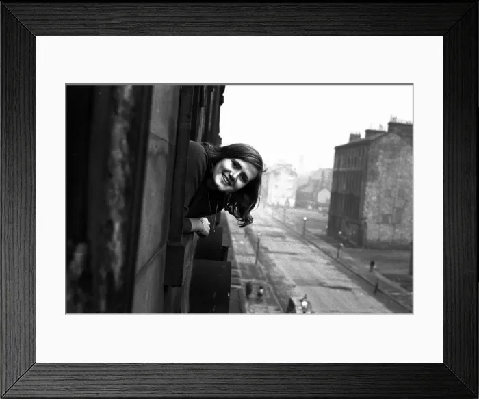 Framed Print : A youth worker pops her head out of one of the windows in a housing slums in the Gorbals Framed Print : A youth worker pops her head out of one of the windows in a housing slums in the Gorbals