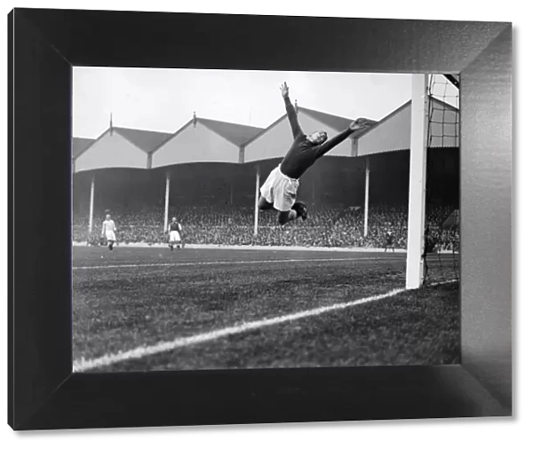 Manchester City goalkeeper Frank Swift making an athletic save in a league match against