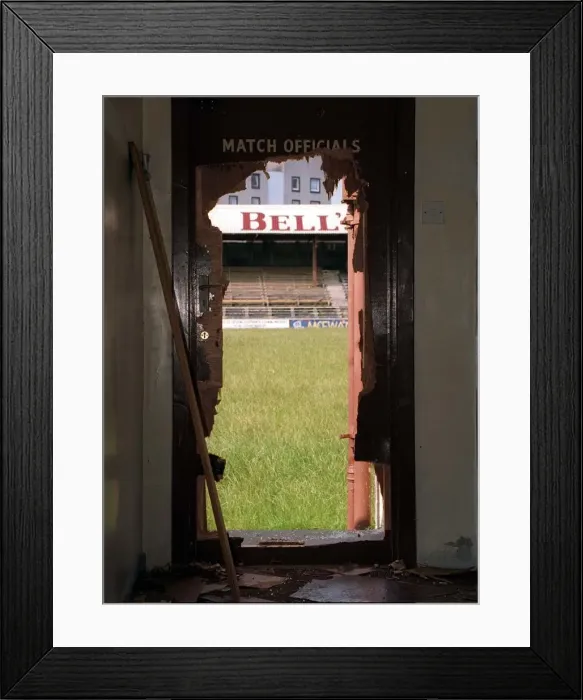 Framed Print : A view through a battered doorway of the stand at Kilbowie Park